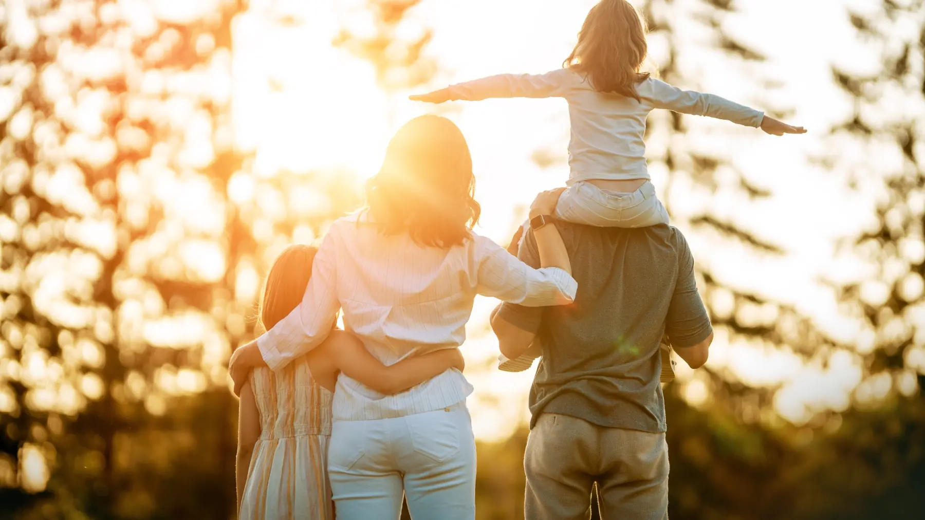 Familia abrazada mirando el atardecer